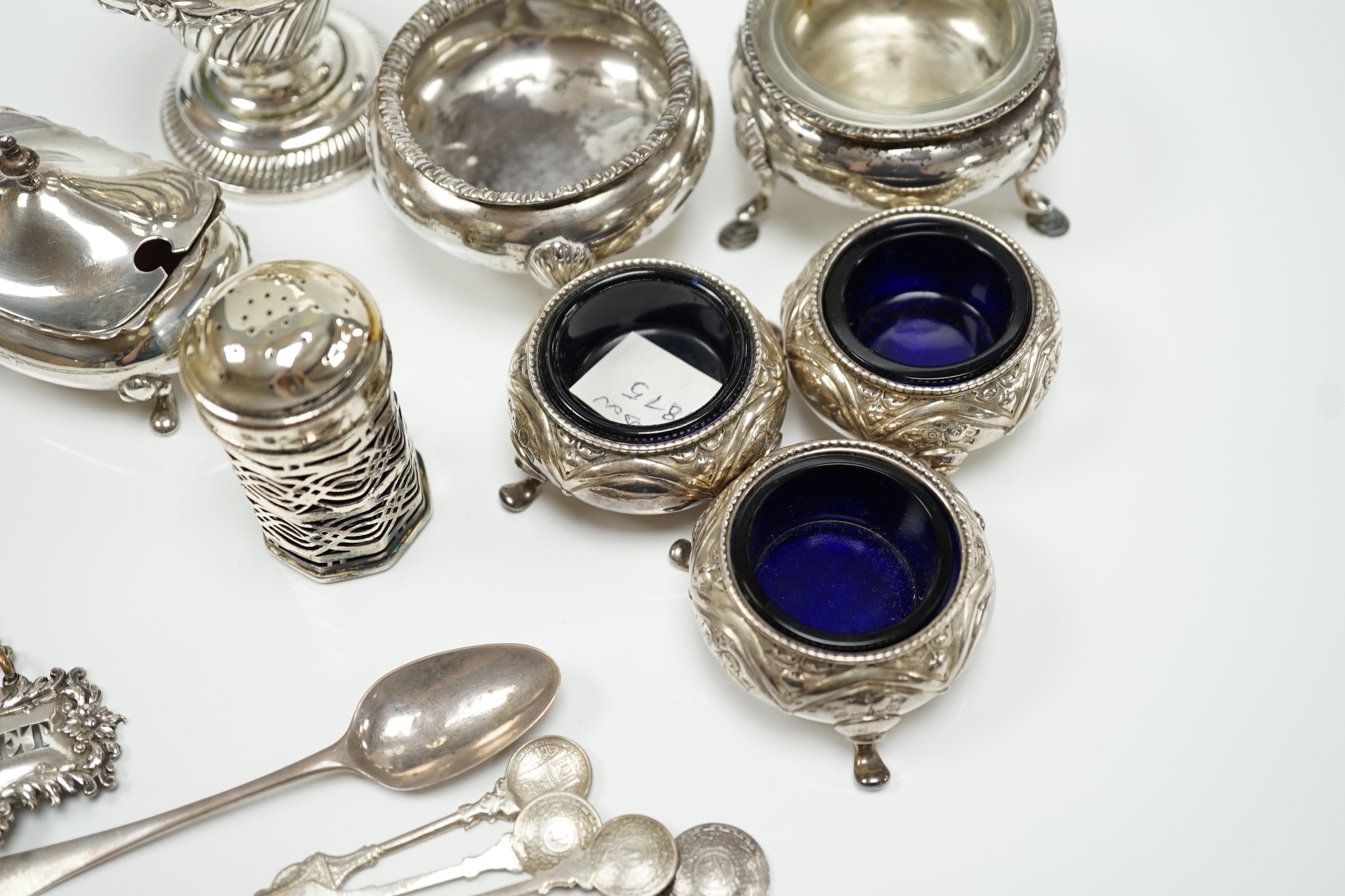 A mixed group of assorted small silver including a sugar caster, two pairs of Victorian bun salts, mustard pot, salt, pepperette, spoon and four white metal spoons.